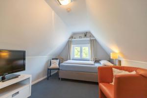 um pequeno quarto com uma cama e uma janela em Hus Mattgoot - private Einzelzimmer im DG und 1 OG em Ording