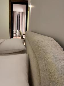 - une chambre avec 2 lits blancs et un miroir dans l'établissement Stunning architect-designed Parisian Flat, à Paris