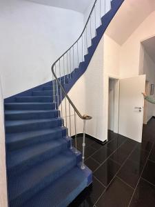 - un escalier dans un bâtiment avec des escaliers bleus dans l'établissement Domum 9 Moderne Ferien- Monteurapartments inkl Wlan und Waschmaschine, à Marl