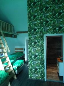 1 Schlafzimmer mit 2 Betten und einer Wand mit Blättern in der Unterkunft Forester in Malmedy