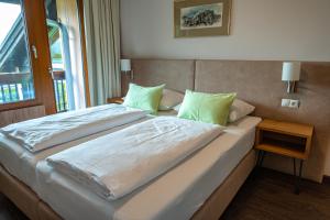 a bedroom with a large bed with green pillows at Hotel Haus Arenberg in Salzburg