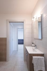 uma casa de banho branca com um lavatório e um espelho em The Residence 2.0 em Galliate