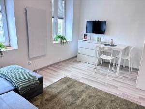 uma sala de estar branca com uma mesa e uma secretária em Mieszkanko w centrum 34 em Lódź