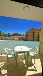 una mesa blanca y sillas en un balcón con vistas en VILLAMAGNA PUEBLO OROPESA en Oropesa del Mar