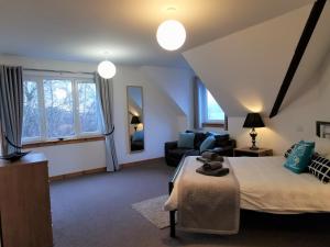 ein Schlafzimmer mit einem Bett, einem Sofa und einem Fenster in der Unterkunft ArdFyne on Lochfyne in Strachur