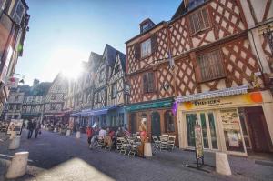 una calle de la ciudad con edificios y gente sentada en mesas en Chambre-Suite (SDB & Cuisinette) centre historique Bourges, en Bourges