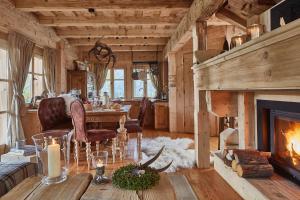 a living room with a fireplace and a table at GORSKA OSADA Luxury Chalets Zakopane in Poronin