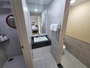 a bathroom with a sink and a mirror at 천지연크리스탈 하버39호텔 in Seogwipo