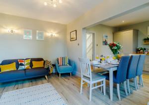 a living room with a table and a blue couch at Alexandra Cottage in Sheringham
