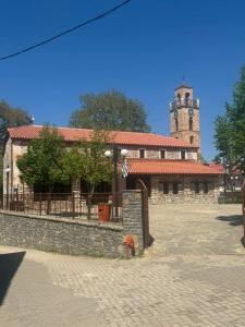 ein Gebäude mit einem Uhrturm und einem Gebäude mit einem Hydranten in der Unterkunft Ellie's house in Kozani