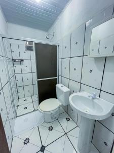 a white bathroom with a toilet and a sink at Pousada Sempre Viva Lençóis in Lençóis