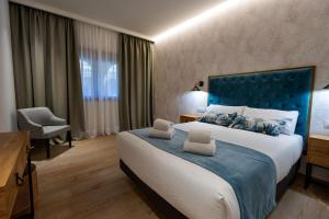 um quarto com uma cama grande e uma cabeceira azul em Complejo Valle Grande em Zarza la Mayor