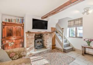 a living room with a fireplace with a tv on top at Flint Cottage - Bodham in Bodham