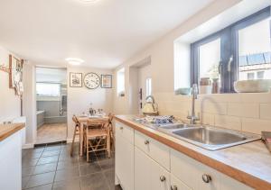 a kitchen with a sink and a table at Flint Cottage - Bodham in Bodham