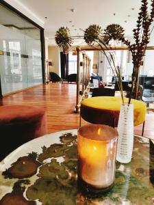 une bougie et un vase sur une table dans une chambre dans l'établissement First Hotel Millennium, à Oslo