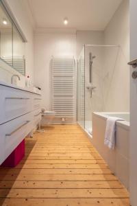 een badkamer met een bad, een douche en een wastafel bij Spacious Belle Epoque House with free parking in Oostende