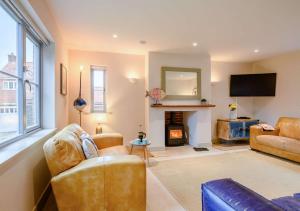 a living room with a couch and a fireplace at Yew Tree House in Weybourne