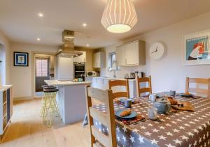 a kitchen and a dining room with a table and chairs at Yew Tree House in Weybourne