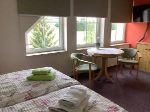 a bedroom with two beds and a table and two chairs at Pension Scherzer in Ohorn