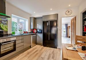 una cucina con frigorifero nero e tavolo di 5 OClock Somewhere a Sheringham