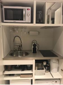 a kitchen with a sink and a microwave at FANTASTIC OCEAN VIEW in Biarritz +7 photos