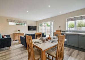 a kitchen and living room with a table and chairs at Sea Glass - Sheringham in Sheringham