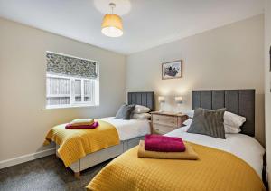 a bedroom with two beds and a window at Sea Glass - Sheringham in Sheringham