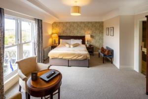 a hotel room with a bed and a desk and a table at West Cork Hotel in Skibbereen