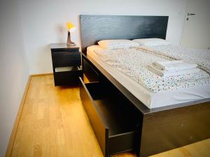 a bedroom with a large bed with a wooden headboard at Rove at CityGate - Exclusive Apartment above City Gate Shopping Center, Vienna with Metro Access in Vienna