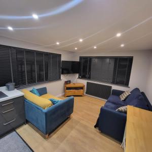 a living room with two blue couches and a table at Town Centre Modern 1 Bed self-contained Apartment in Newbury