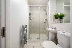 a bathroom with a shower and a toilet and a sink at GuestReady - Bow luxury haven in London