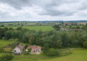 an aerial view of a house in a green field at Aurora Cottage in Little Barningham