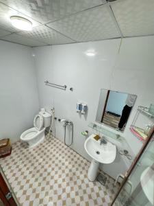 a bathroom with a toilet and a sink and a mirror at Nhà nghỉ Thành Đạt in Hai Phong