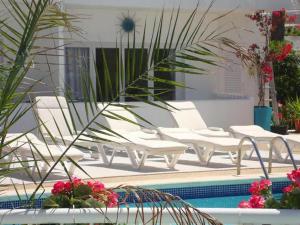einen Pool mit weißen Liegestühlen und einer Palme in der Unterkunft Apartamento Ciel Azul in Cala Llena
