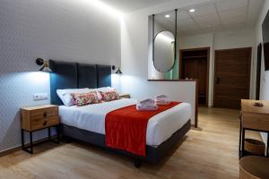 una camera d'albergo con letto e specchio di Complejo Valle Grande a Zarza la Mayor