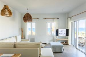 a living room with a couch and a tv at Alsea Seafront Apartments in Agia Pelagia Kythera in Agia Pelagia