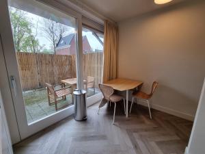 a small room with a table and chairs and a window at Molenzicht in Alkmaar