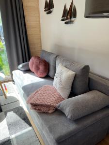 ein Sofa mit Kissen darauf in einem Wohnzimmer in der Unterkunft Tinyhouse Frida moderne & stilvolle Auszeit am See Natur & Ruhe in Stuer Mecklenburgische Seenplatte Klima, Grill in Stuer + 19 Fotos