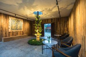 a lobby with chairs and a palm tree in a room at ARTOTEL Haniman Ubud in Ubud