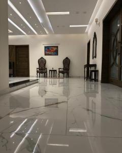 a lobby with two chairs and a table at AAS HOSTS in Islamabad