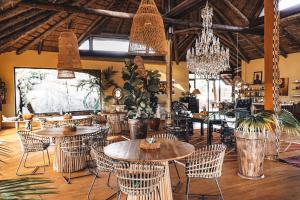 un restaurante con mesas, sillas y lámparas de araña en Ohorongo Tented Camp en Outjo