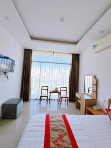 a bedroom with a bed and a table and chairs at Hotel Minh Thắng in Vung Tau
