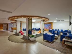 a lobby with blue couches and chairs in a building at Zone Connect by The Park Indore in Indore