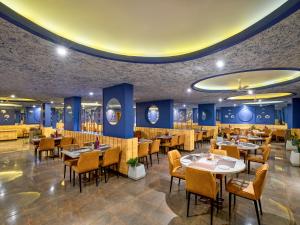 a restaurant with tables and chairs and blue walls at Zone Connect by The Park Indore in Indore