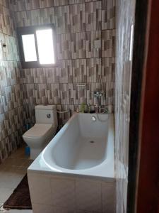 a bathroom with a bath tub and a toilet at Résidence beau-lieu in Yaoundé