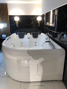 La salle de bains est pourvue d'une baignoire blanche et de carrelage noir. dans l'établissement Rent Room 4 Rolandi Apartments, à Pogradec