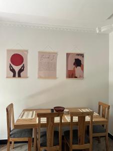 une table et des chaises dans une pièce ornée de peintures murales dans l'établissement Green Living Apartment, à Nkoanrua