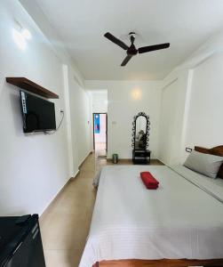 a bedroom with a large bed with a ceiling fan at Sun and Sea, Calangute in Goa