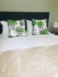 a bed with two pillows on top of it at Happy Daze (Self catering) in Swellendam