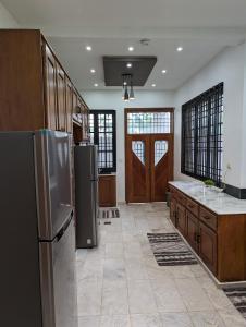 a large kitchen with stainless steel appliances and wooden cabinets at West Coast Villa in Limbe